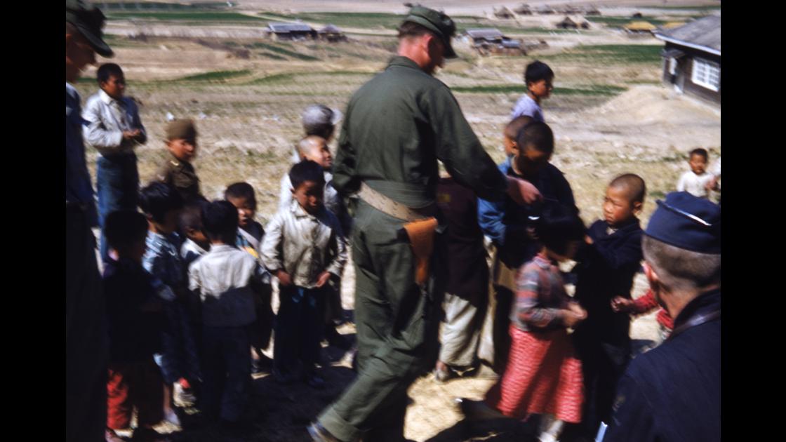 1952년 대구 K-2비행장 밖 마을 주변 어린이들에게 먹을 것을 나누어 주는 미군 병사 썸네일