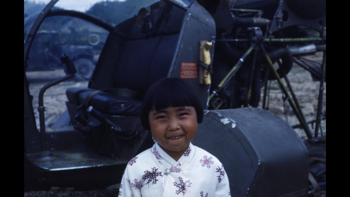 1952년 7월 강원도 김화읍 미육군 제25보병사단 제8209 야전외과병원 환자 수송용 헬기 앞의 소녀 썸네일
