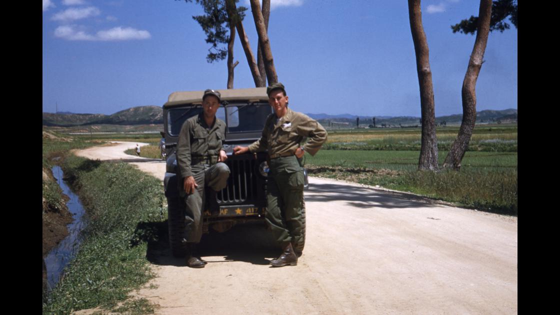 1951년 도로 위 소나무 아래에 지프차 옆에서 촬영한 미군 병사 2명 썸네일