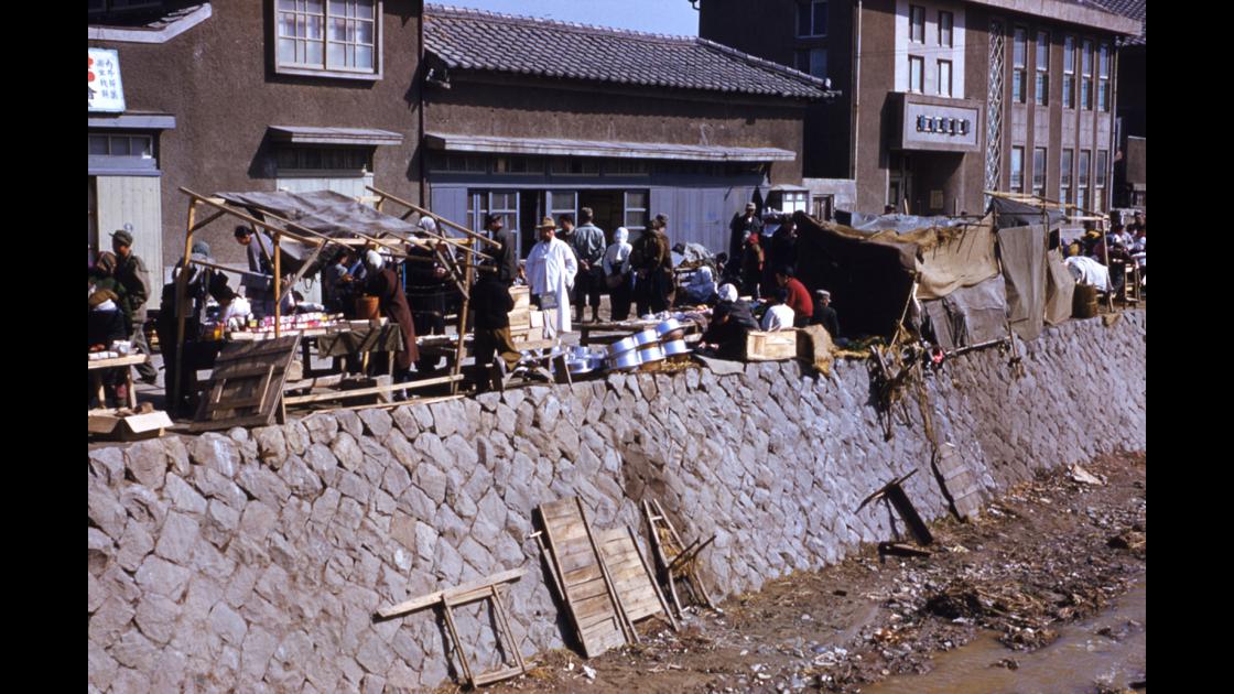 1952년 보수천 하구 박내과의원 옆 둑길 따라 펼쳐진 노점상들 썸네일