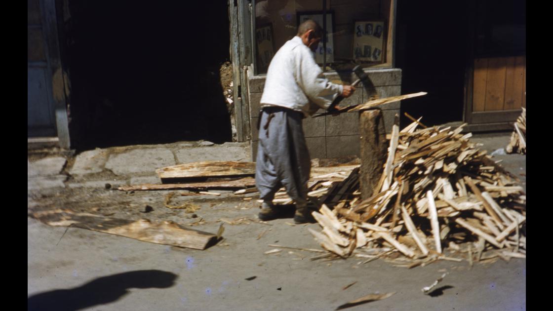 1952년 부산 중구 부평동 뒷길의 사진관 앞에서 장작을 패는 노인 썸네일