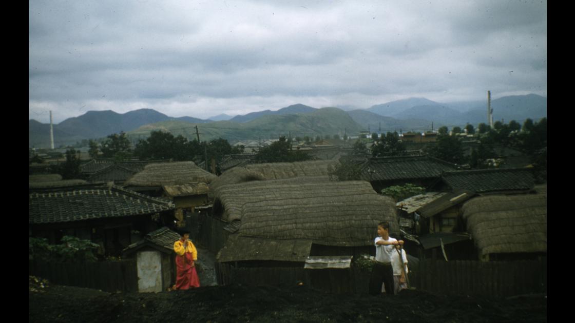 1954년 부산 동래구 어느 마을의 초가와 기와지붕 가옥들과 이야기를 나누는 소년 소녀 썸네일
