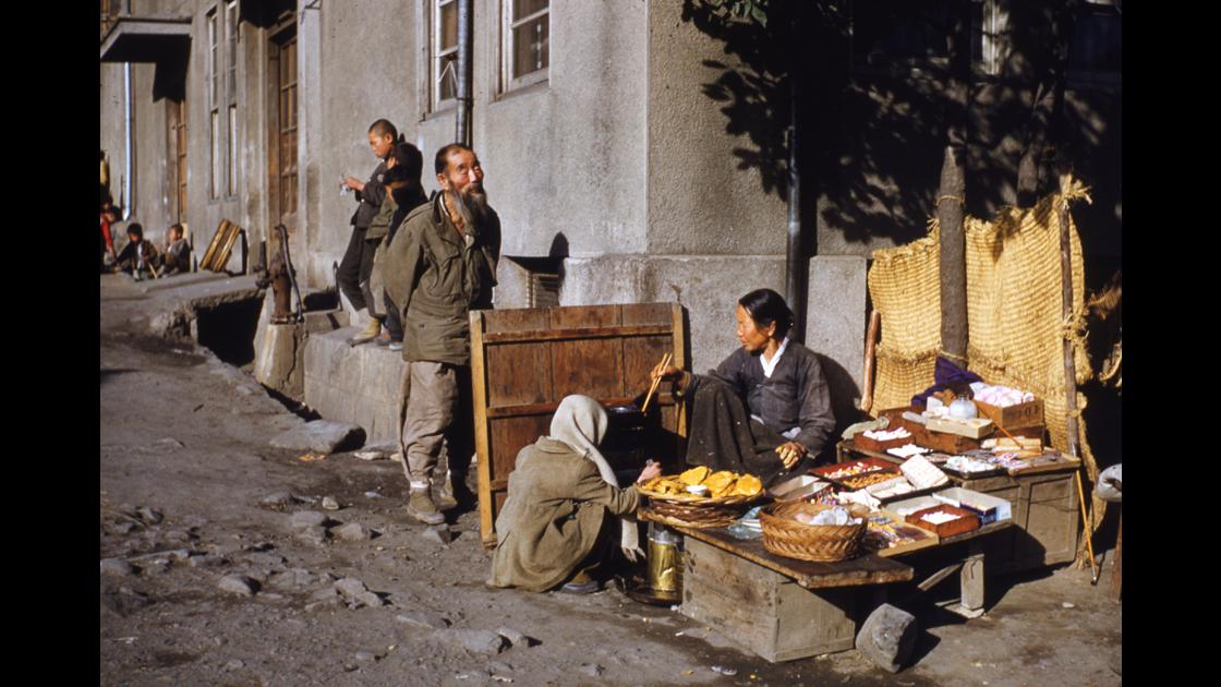 1952년 마산 어시장 인근 거리에서 사탕과 과자를 팔면서 전을 굽고있는 노점상 썸네일
