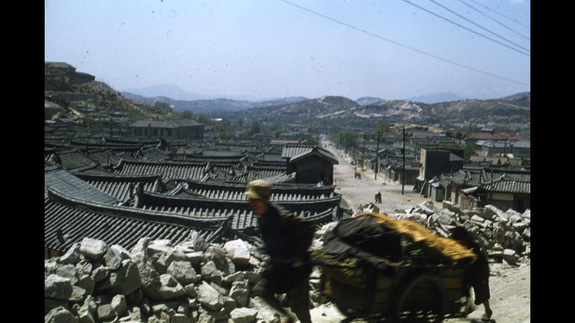 1954년 서울 남산자락의 한옥마을 뒤로 배추를 실은 리어카를 끌고가는 사람 썸네일