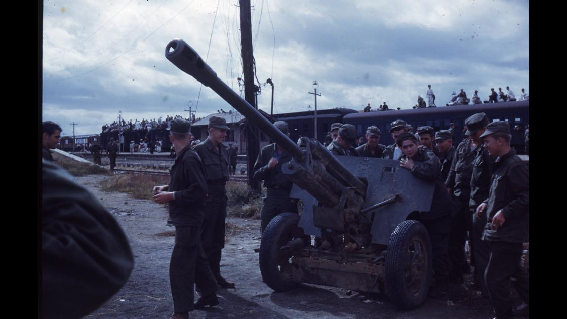 1951년 대전역 구내에서 고사포를 에워싸고 이야기를 나누는 미 해병대 군인들과 그 옆의 피란민을 태운 열차 썸네일