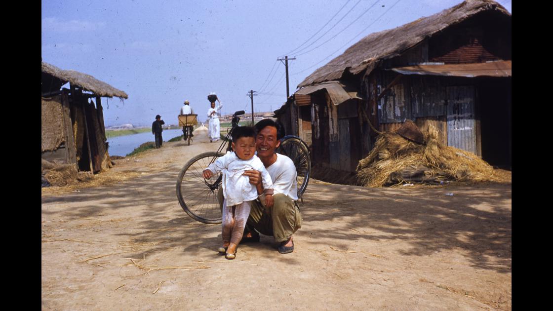 1952년 자전거 옆에서 포즈를 취한 아버지와 아이 썸네일