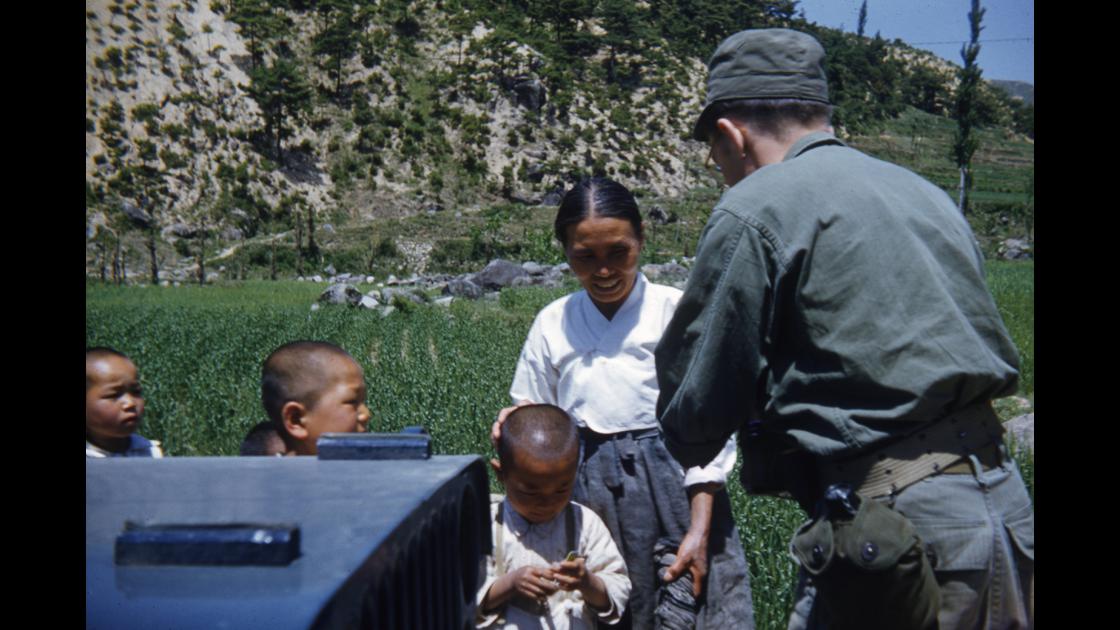 1952년 지프에서 내려 아이들에게 과자를 나누어주는 미군 병사 썸네일