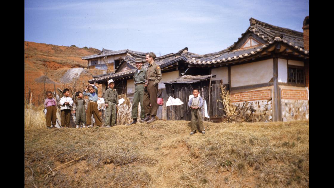 1953년 서울 영등포 언덕배기의 기와 저택 옆에서 미군 병사와 아이들 썸네일